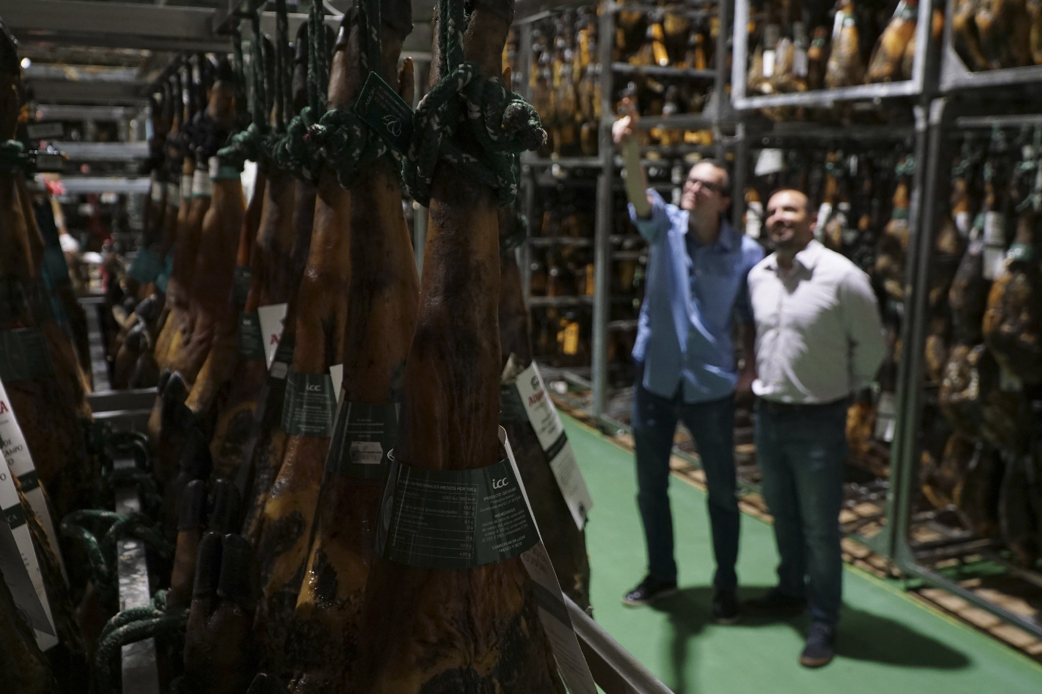 Miquel and Jose María checking hams in the warehouse.
